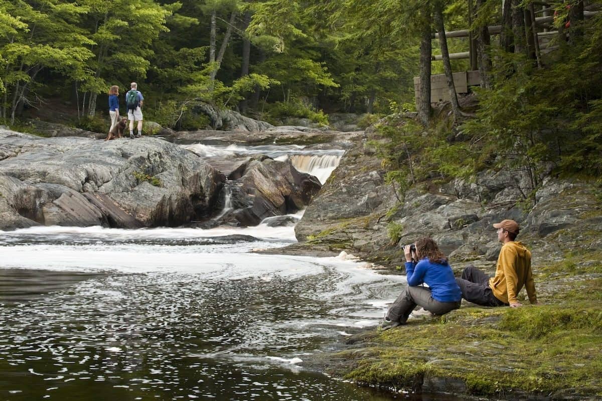 Walkers on the rocks beside the Mersey River at Kejimkujik National Park