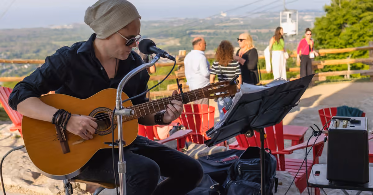A guitarist playing to a small outdoor crowd at Blue Mountain Village