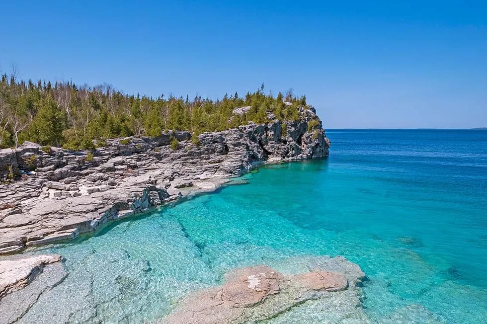 White boulder beach and clear shallow water below the cliffs at Bruce Peninsula