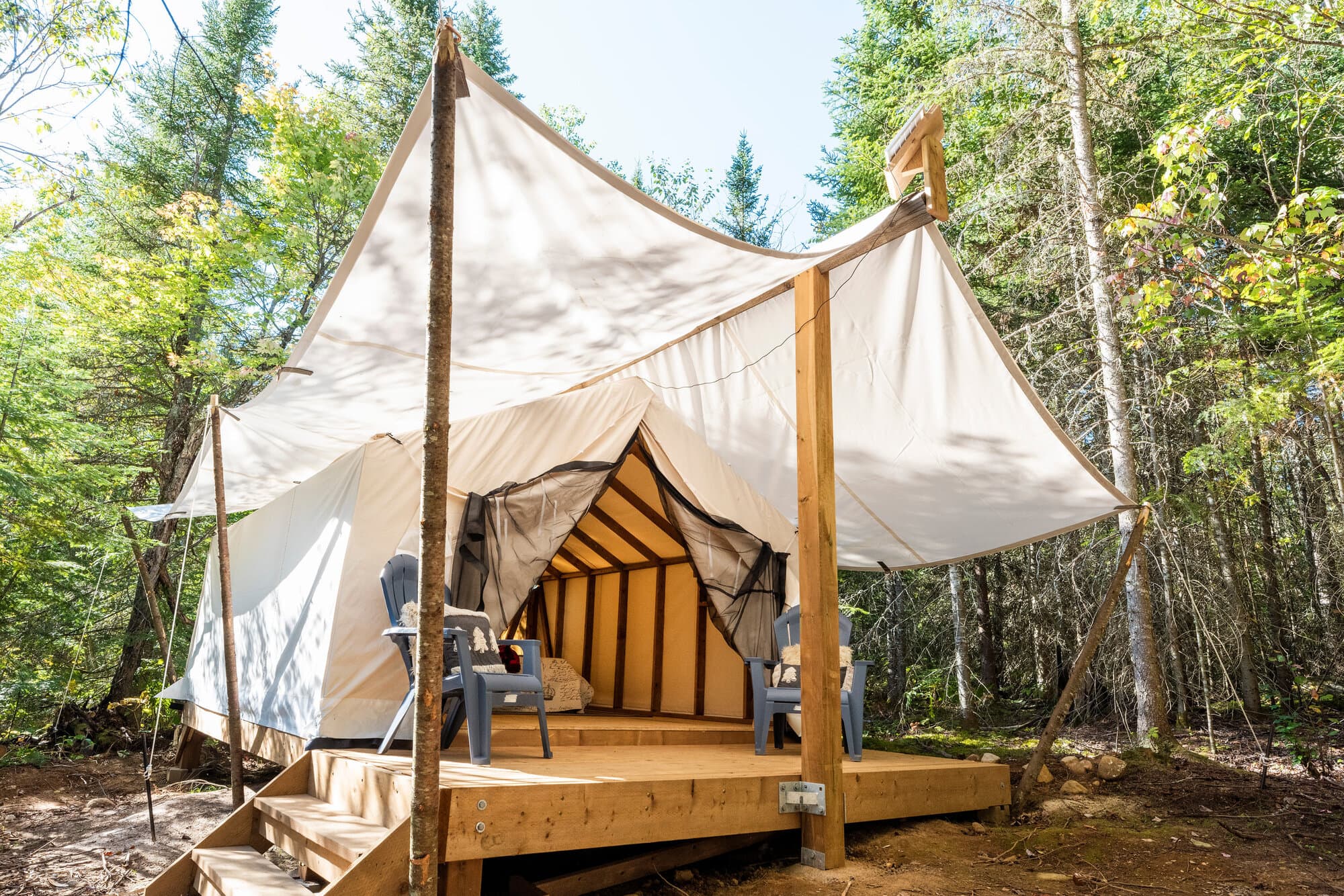 A safari tent on a wooden deck in the forest at Four Corners Algonquin