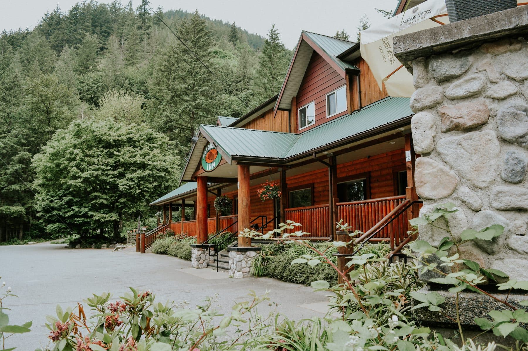The Sasquatch Inn, a timber roadhouse inn with a pub, surrounded by forest