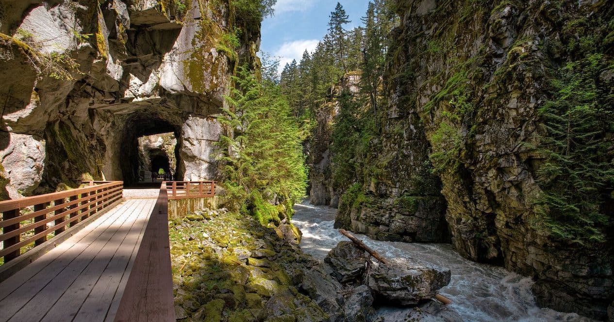 The boardwalk through Coquihalla Canyon with a tunnel mouth ahead and the river below