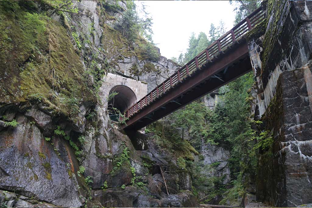 The old railway bridge spanning the Coquihalla canyon between two tunnel mouths