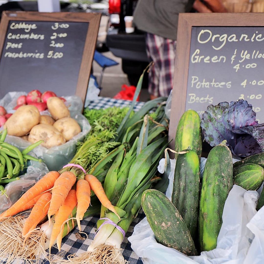 Vegetables and hand-written price boards on a stall at the Front Street Farmers' Market