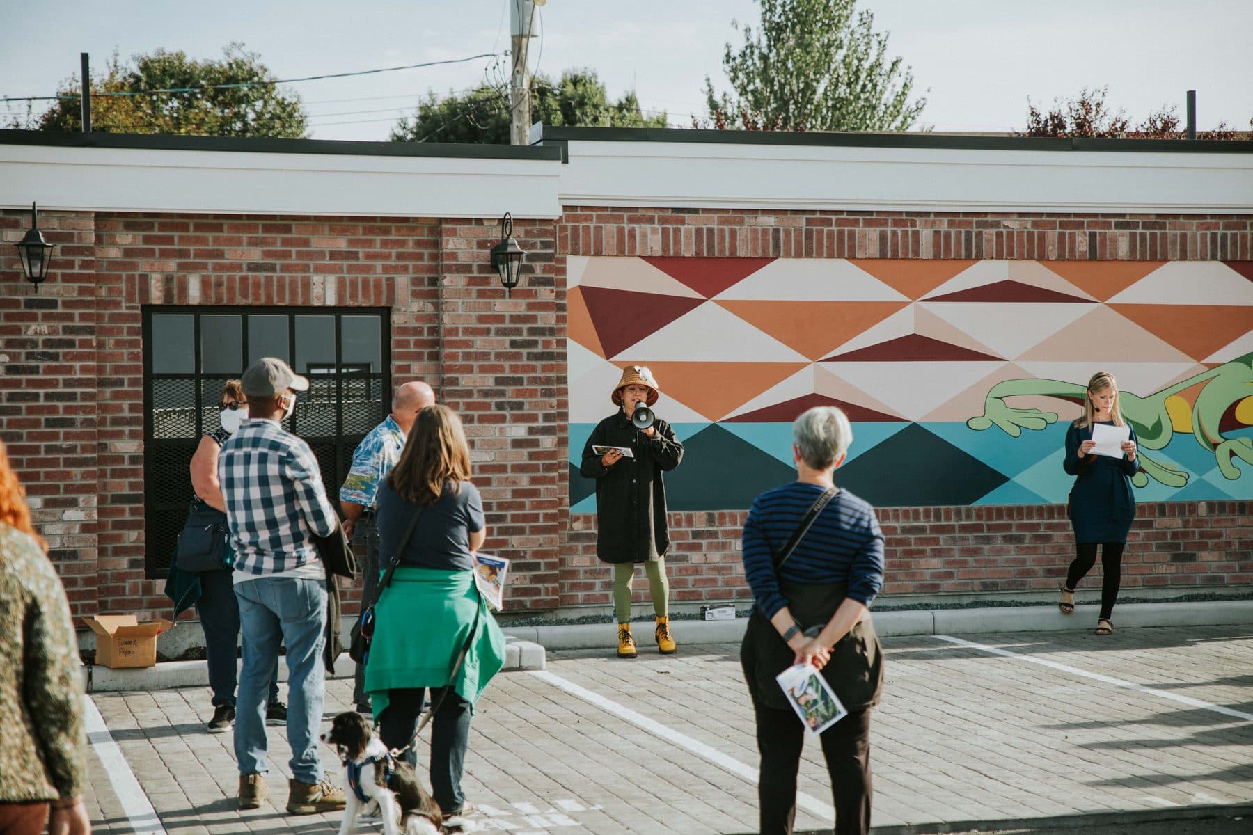 Visitors on a guided walk past a geometric mural