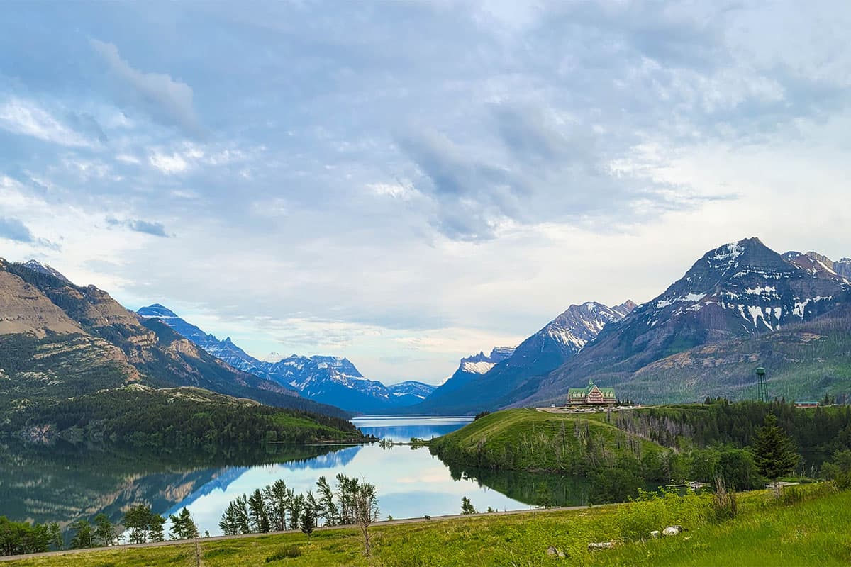 Upper Waterton Lake reflecting the mountains, with prairie grass in the foreground