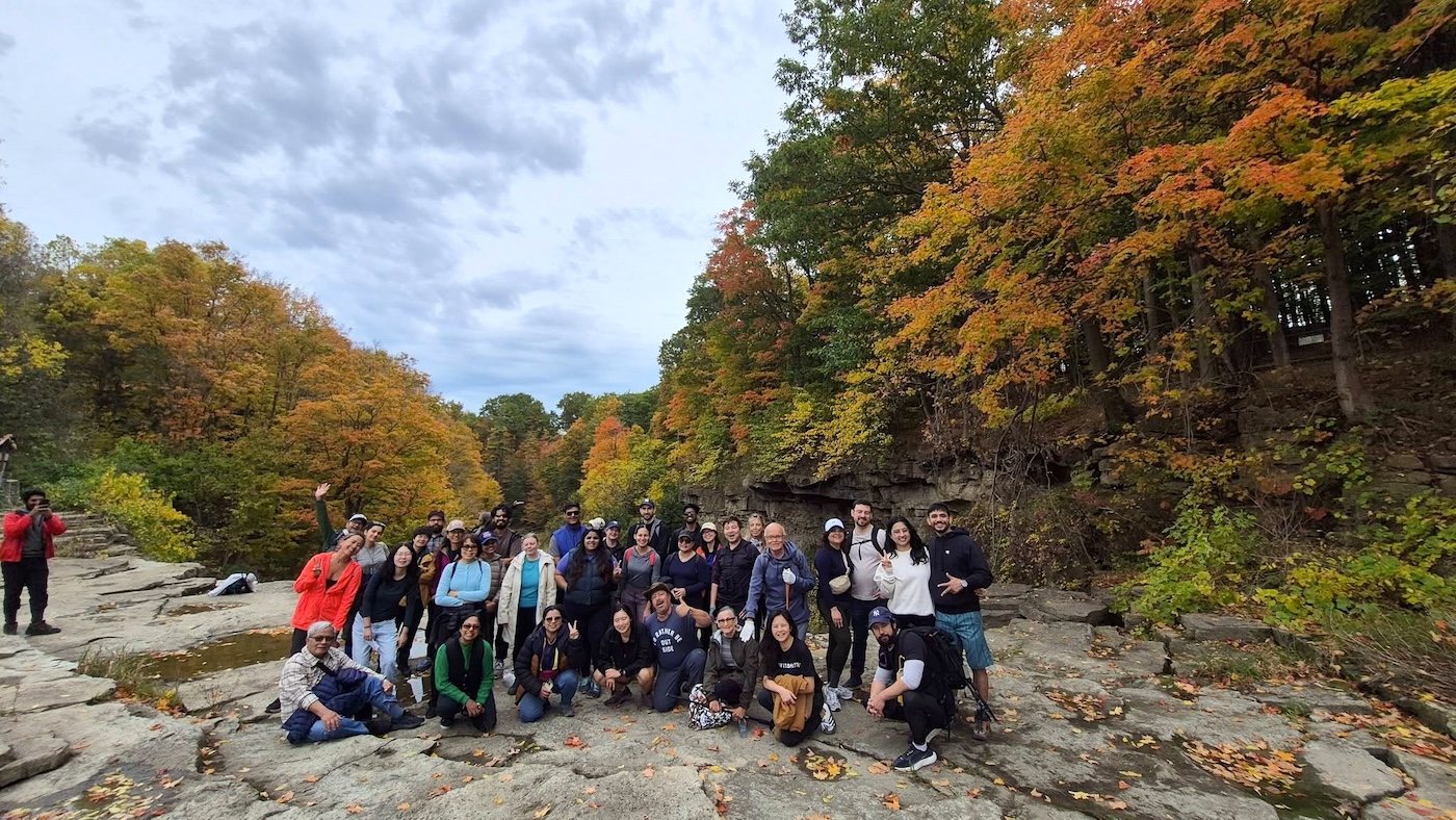 A Parkbus group together on the rocks among orange and red autumn trees